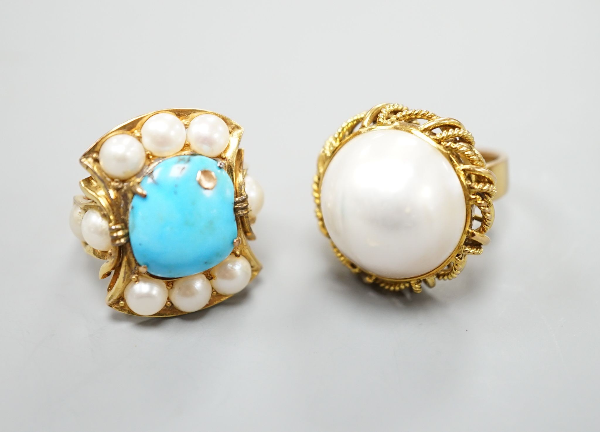 A 14k yellow metal and mabe pearl set dress ring and a similar split pearl and turquoise set dress ring, both size M, gross weight 21.7 grams.